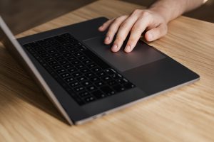 Man touching touchpad on Macbook.
